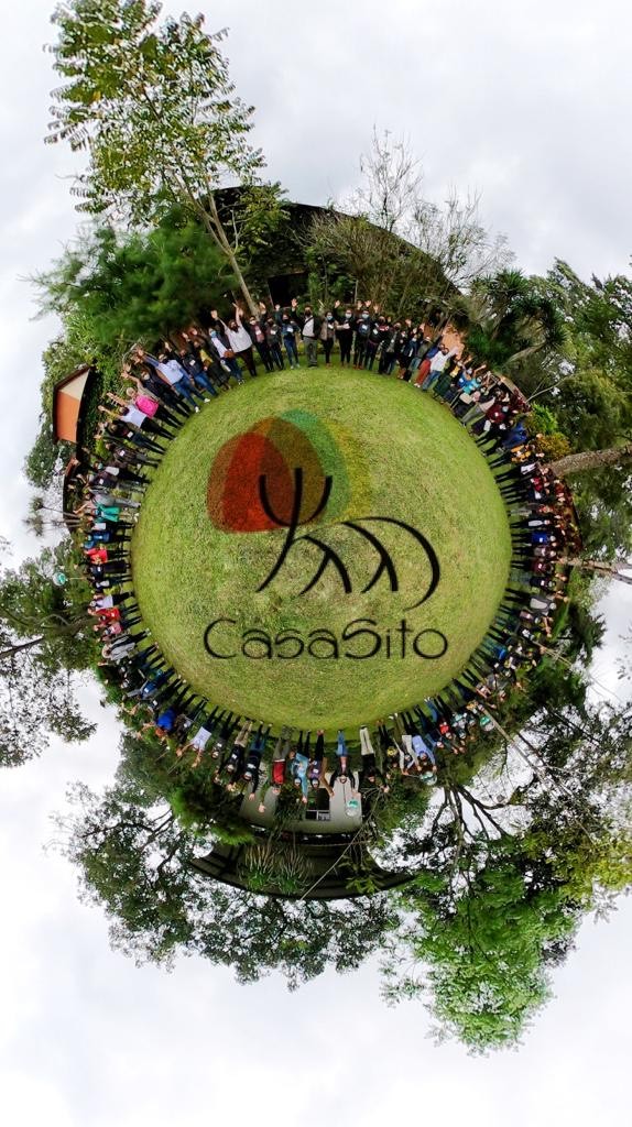 Aerial photo of CasaSito members and volunteers standing around their logo.