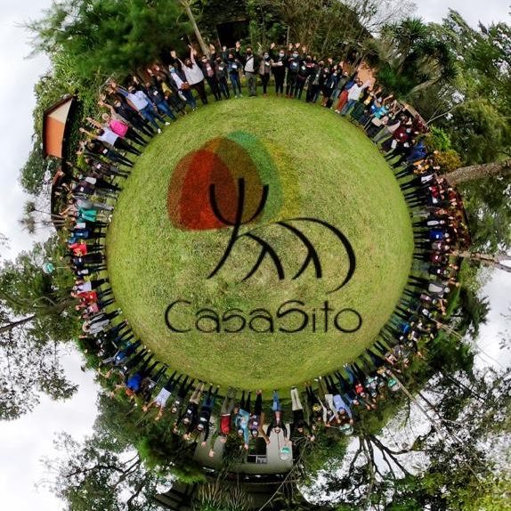 Aerial photo of CasaSito members and volunteers standing around their logo.
